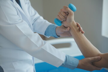 Doctor or physical therapist examines back pain and spinal area to give advice within the rehabilitation center.