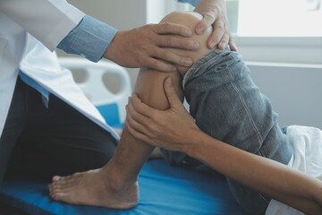 Doctor or physical therapist examines back pain and spinal area to give advice within the rehabilitation center.
