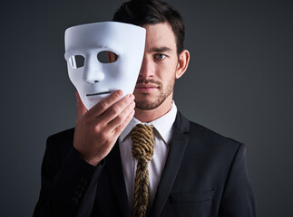 Two faced portrait, mask and fake businessman in a studio with serious face with secret...