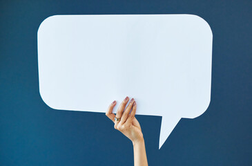 Hand, speech bubble and woman in studio with banner, news or announcement on blue background....
