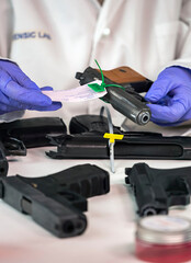 Fototapeta na wymiar Police scientist notes serial number on sealed firearm in crime lab, conceptual image