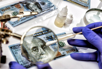 Police scientist investigates fake dollar bills and passports in criminal investigation unit,...