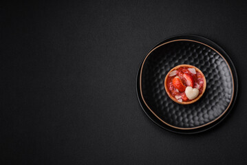 Delicious fresh sweet tartlets with strawberries and coconut flakes