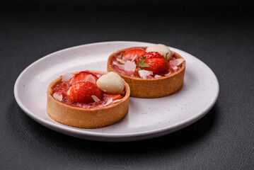 Delicious fresh sweet tartlets with strawberries and coconut flakes