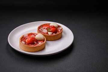 Delicious fresh sweet tartlets with strawberries and coconut flakes