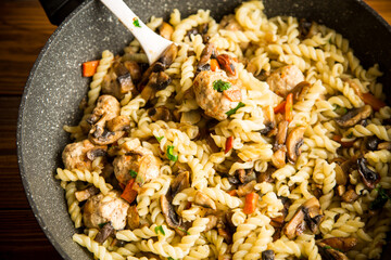 vermicelli cooked with mushrooms, meat and vegetables in a frying pan