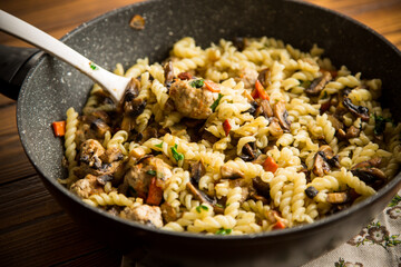 vermicelli cooked with mushrooms, meat and vegetables in a frying pan