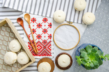 Round hoop frame, wooden spoons, meringue homemade zephyr in wooden tray, embroided napkin with traditional ornament and echeveria plant. Mockup card. Template for recipes, food menu, craft