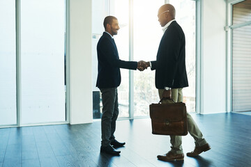 Handshake, partnership and travel for business men in office for onboarding, collaboration and...