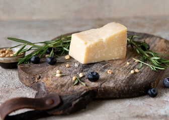 parmesan cheese, rosemary, blueberries and pine nuts on a wooden board