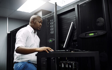 Engineer, black man or coding on laptop in server room for big data, network glitch or digital...