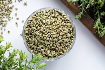 Bundle of fresh green aromatic thyme herbs with dried thyme seeds in a bowl. 