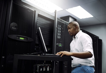 IT support, black man or coding on laptop in server room for big data, network glitch or digital website. Code, fixing or technician typing on computer testing UX, programming or software development