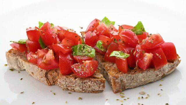 Tomato bruschetta with wholemeal bread, tomatoes, oregano, basil and extra virgin olive oil isolated on white background, close-up.