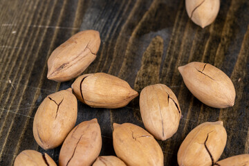 cracked unpeeled pecans close-up on the table