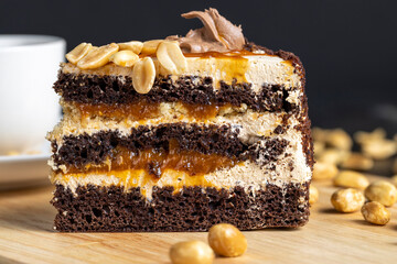 a piece of chocolate cake with caramel and peanuts