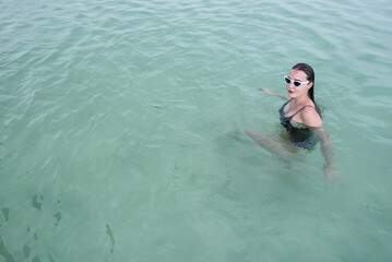 a caucasian girl is swimming in swimming wear in a swimming pool