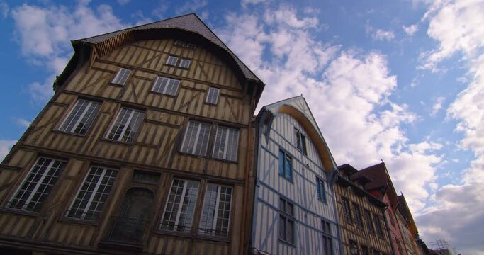 Time lapse view of a beautiful street with old traditional French houses in the center of Troyes with clouds in the background. Establishing shot. Legacy of French history. Colorful houses in France