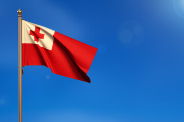 Tonga. Flag blown by the wind with blue sky in the background.