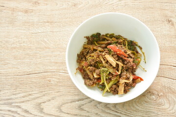 spicy stir fried bamboo shoot and chop beef meat with basil leaf in bowl
