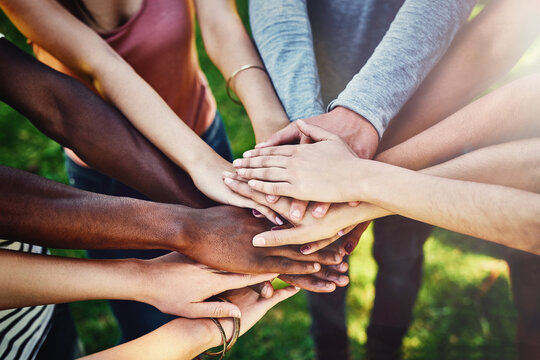 Hands, diversity and friends at a park for teamwork, partnership and volunteering mission from above. Top view, people and hand support by volunteer group outdoor for community, charity and activism