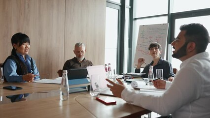Multiethnic smiling colleagues discuss business development at meeting in coworking room - Powered by Adobe