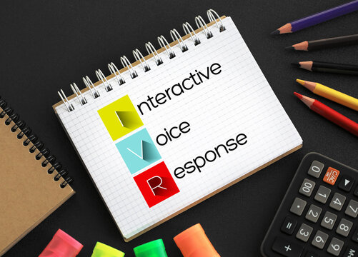 IVR - Interactive Voice Response acronym on notepad, technology concept background