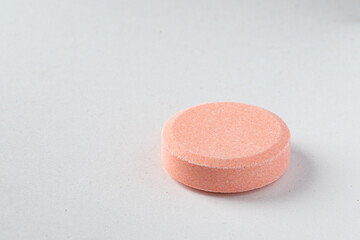 Close up of of chewable antacid acid reducer tablets with fruit flavor on white paper background