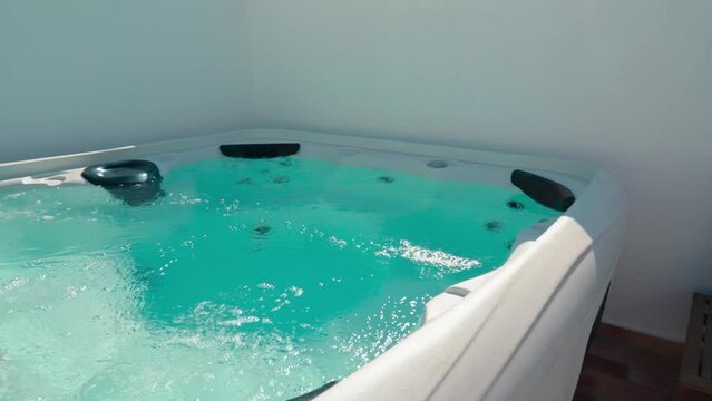 Slow wide shot of a private jacuzzi for rent in summer for hydromassage.