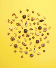 Pattern of nuts mix on yellow background