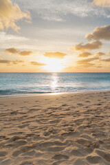 Fototapeta na wymiar Sunset / Sunrise with the reflection over the blue ocean and yellow sandy beach.