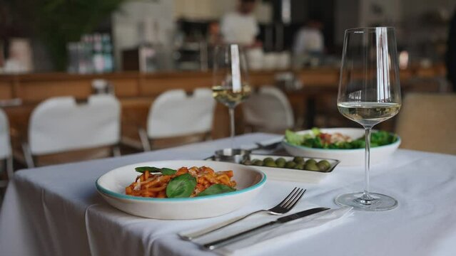 Side view of table set with glasses of wine and food in cafe
