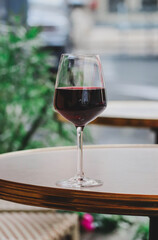A glass of red wine on the summer terrace of a Parisian restaurant