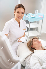 Cosmetologist conducts a course of anti-aging procedures for a client