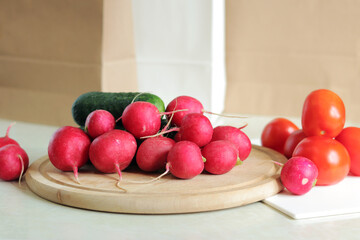 Fresh vegetables on the table, side view. Tomatoes, cucumbers and radishes. Vegetables for salad. Set of various fresh ingredients for making salad. Healthy food concept. Close-up