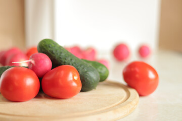 Fresh vegetables on the table, selective focus. Tomatoes, cucumbers and radishes. Vegetables for salad. Set of various fresh ingredients for making salad. Healthy food concept. Close-up