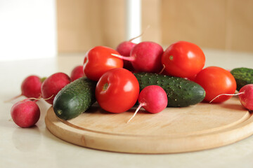 Fresh vegetables on the table, side view. Tomatoes, cucumbers and radishes. Vegetables for salad. Set of various fresh ingredients for making salad. Healthy food concept. Close-up