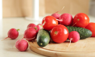Fresh vegetables on the table, side view. Tomatoes, cucumbers and radishes. Vegetables for salad. Set of various fresh ingredients for making salad. Healthy food concept. Close-up