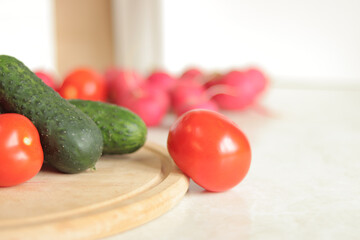 Fresh vegetables on the table, selective focus. Tomatoes, cucumbers and radishes. Vegetables for salad. Set of various fresh ingredients for making salad. Healthy food concept. Close-up