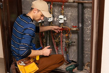 The technician checking the heating system with tablet in hand