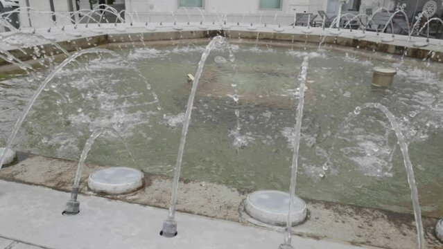 slow motion di getti d'acqua di una fontana in una piazza cittadina