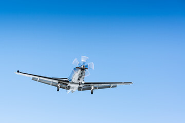 Fototapeta na wymiar Elegant private jet with powerful turbine engine gracefully descends, making a smooth landing under a picturesque blue sky backdrop.
