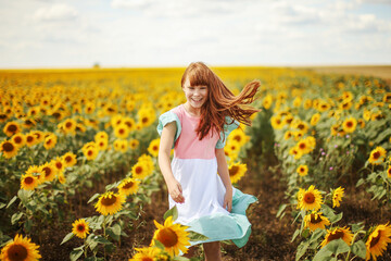 Happy little girl on the field of sunflowers in summer. beautiful little girl in sunflowers