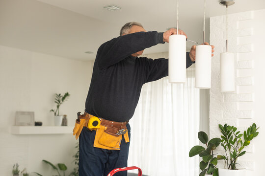 An elderly man with a shoe in the workshop.