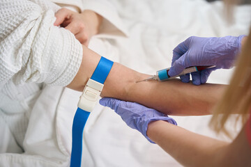 Nurse giving intramuscular injection in female arm