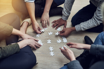 Hands, business people and puzzle in circle, diversity or teamwork for problem solving, solution or above game. Group, planning and helping hand for support, synergy and team building on office floor