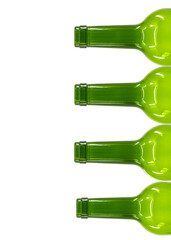 Tops and necks of empty wine bottles stacked on tyop of one another isolated on a plain white...