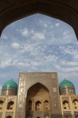 Architectural ensemble Po-i Kalyan in Bukhara, Uzbekistan. Mir-i Arab madrasah through arch