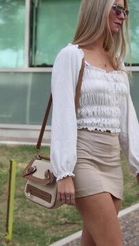 Mujer con lentes de sol caminando paneo der a izq, en una tarde soleada de oto&ntilde;o  