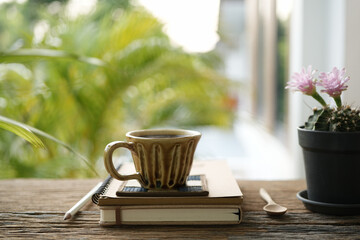 coffee cup and notebook and cactus on table at outdoor